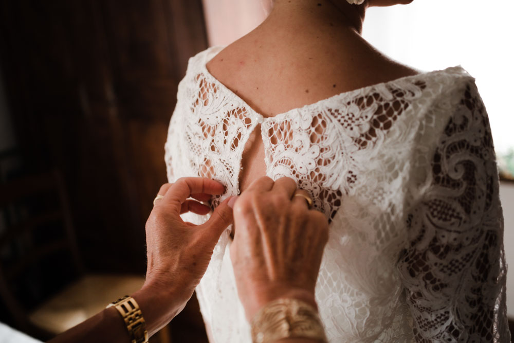 Fermeture du dernier bouton de la robe de mariée